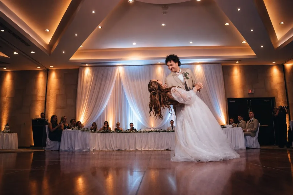 Bride and groom first dance with warm amber uplighting and draped backdrop at a Niagara wedding