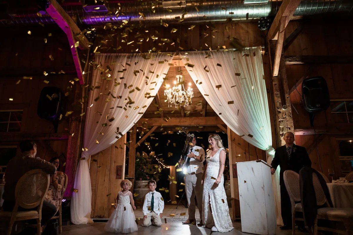 Gold confetti cannon burst over the couple at a Niagara barn wedding