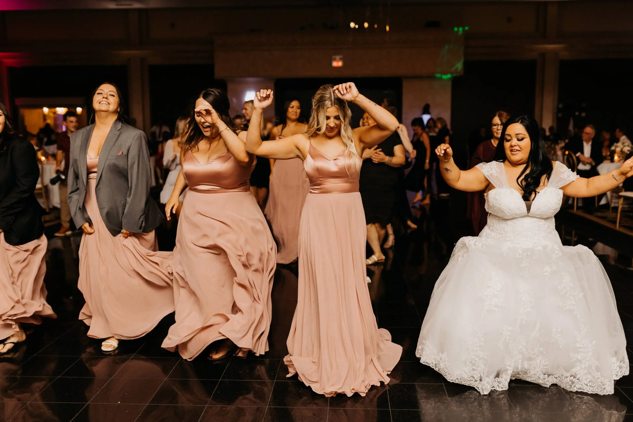 Bride and wedding party dancing together during the reception
