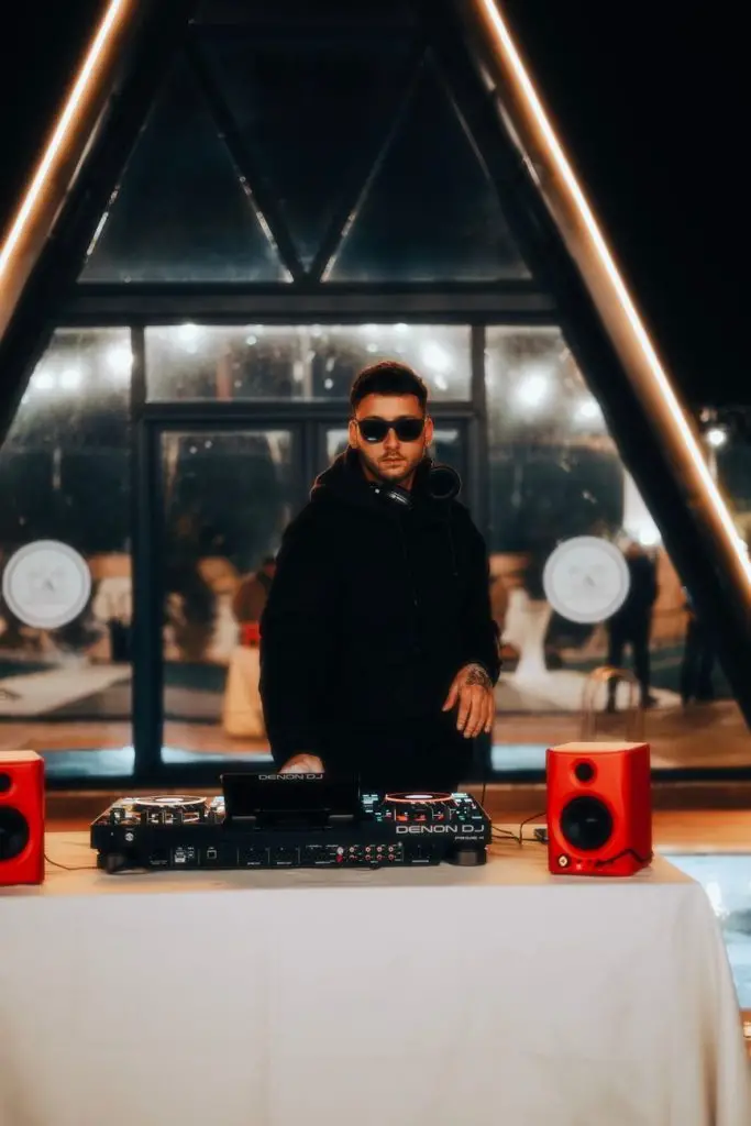 DJ booth set up in a Niagara Falls ballroom with clean white facade and speakers